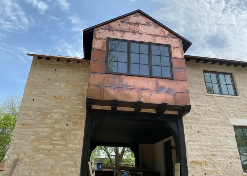 Copper metal panel facade on a stone building for Roof Repair in Lavon